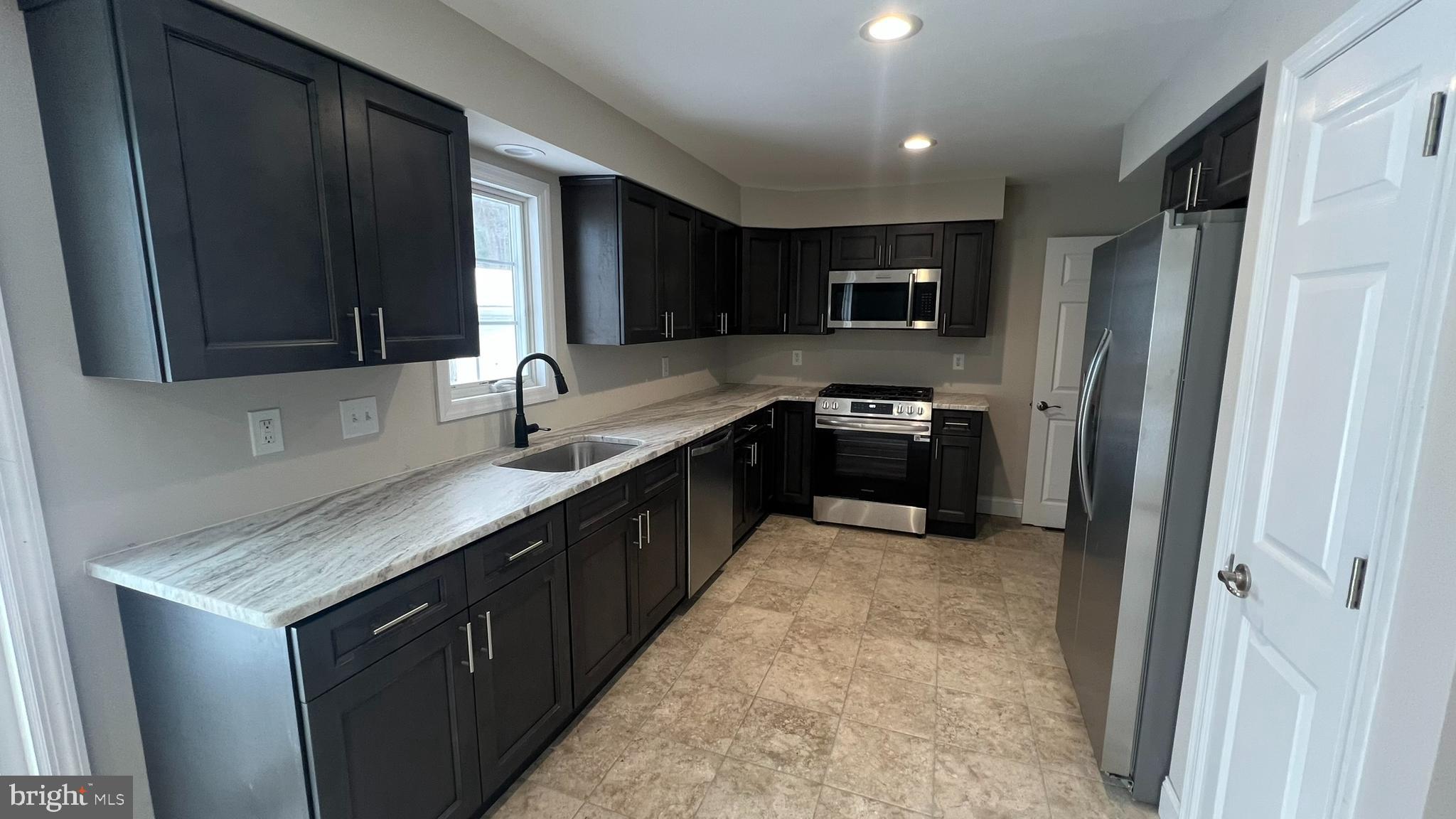 220 Harvard Avenue Stratford, NJ 08084 - Photo 16 of 33 a kitchen with granite countertop stainless steel appliances a sink stove and refrigerator