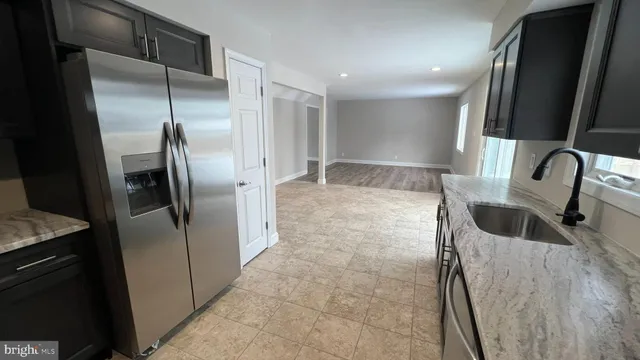 a kitchen with stainless steel appliances granite countertop a refrigerator and a sink