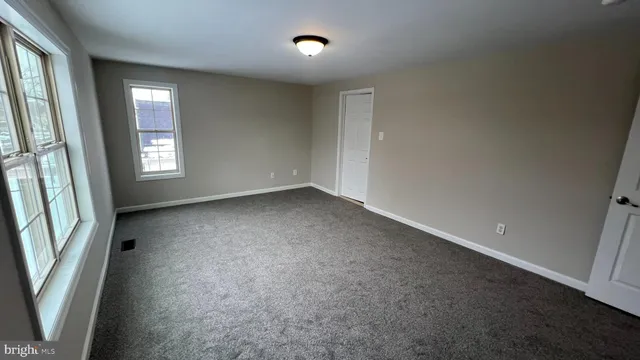 an empty room with windows and entrance