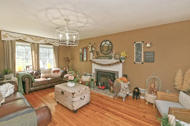 a living room with furniture a fireplace and a chandelier