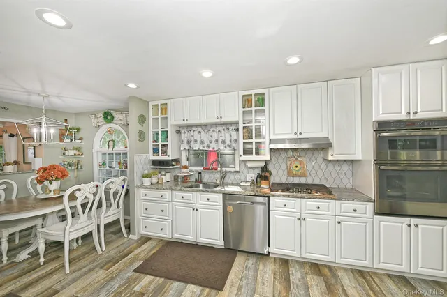 a kitchen that has a lot of cabinets in it and wooden floors