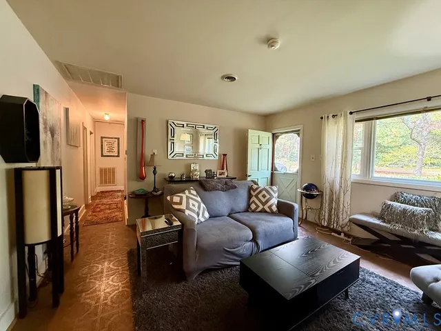 a living room with furniture fireplace and a large window