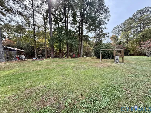 a view of backyard with swimming pool and seating space