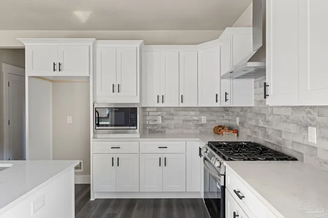 a kitchen with stainless steel appliances white cabinets and a stove