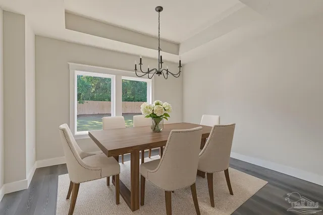 a view of a room with wooden floor chandelier and windows