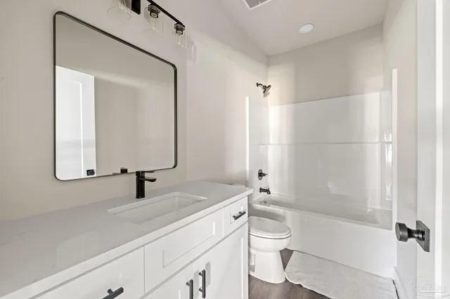 a bedroom with a bed a chair and painting on the wall