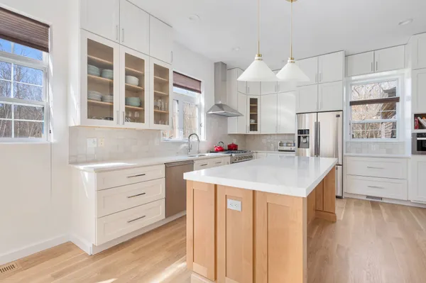 a kitchen with a stove cabinets and wooden floor