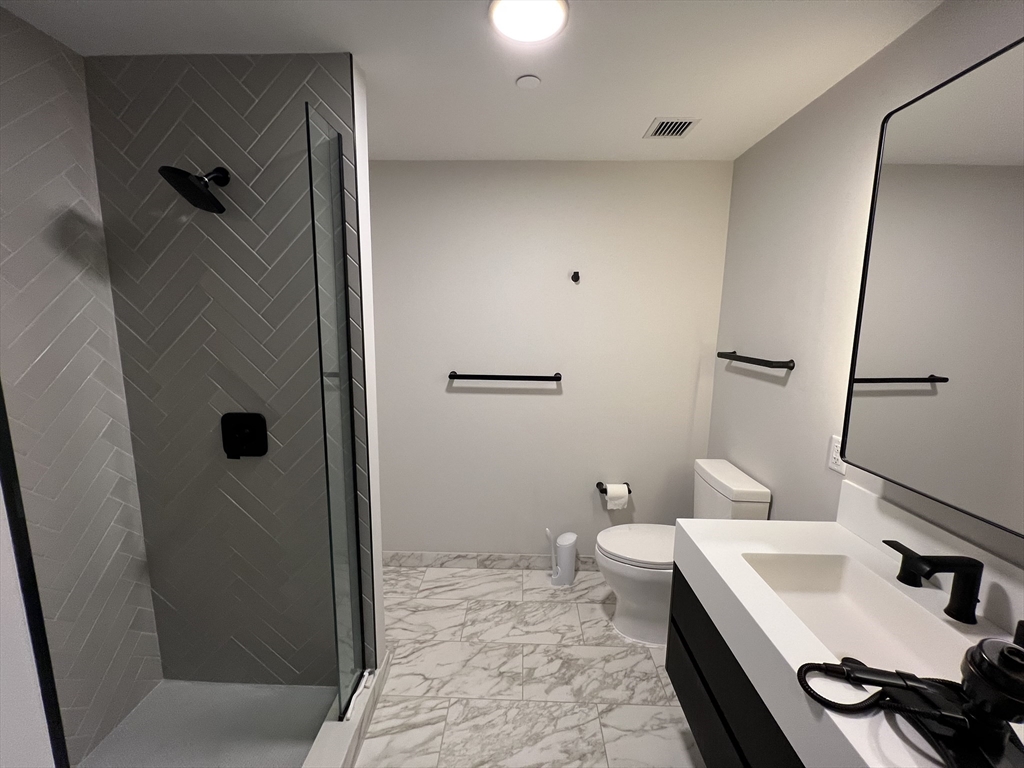 55 Lagrange Street, Unit 1108 Boston, MA 02116 - Photo 12 of 33 a bathroom with a sink a toilet a mirror and shower