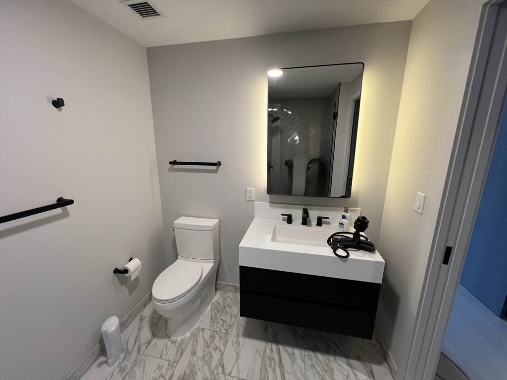 55 Lagrange Street, Unit 1108 Boston, MA 02116 - Photo 14 of 33 a bathroom with a sink toilet and mirror