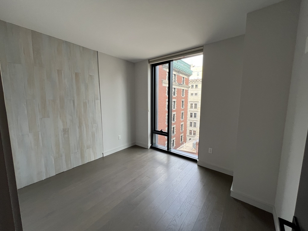55 Lagrange Street, Unit 1108 Boston, MA 02116 - Photo 21 of 33 an empty room with wooden floor and natural light
