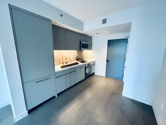 a kitchen with granite countertop white cabinets and white appliances