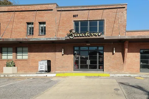 a view of a building and a cars park on the road