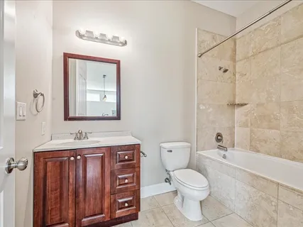 a bathroom with a toilet a sink a mirror a bathtub and vanity