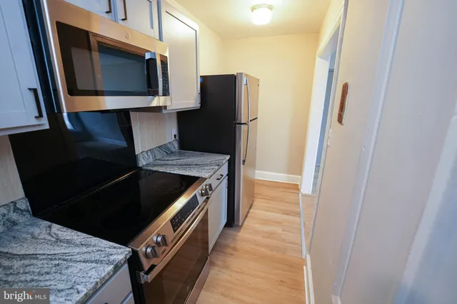 a kitchen with granite countertop a refrigerator and a stove