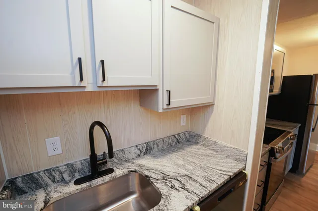 a kitchen with a sink a stove and cabinets
