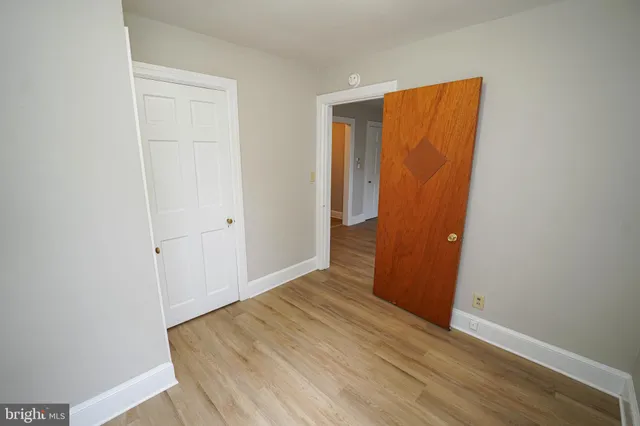 an empty room with wooden floor and closet
