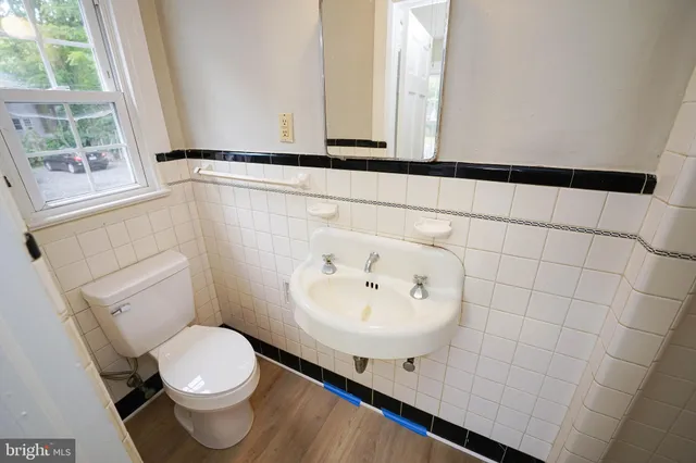 a bathroom with a sink a toilet and mirror