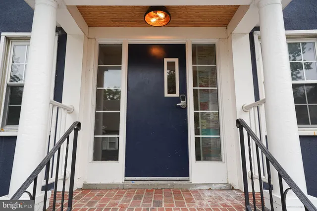 a view of an entryway with a floor to ceiling window and wooden floor