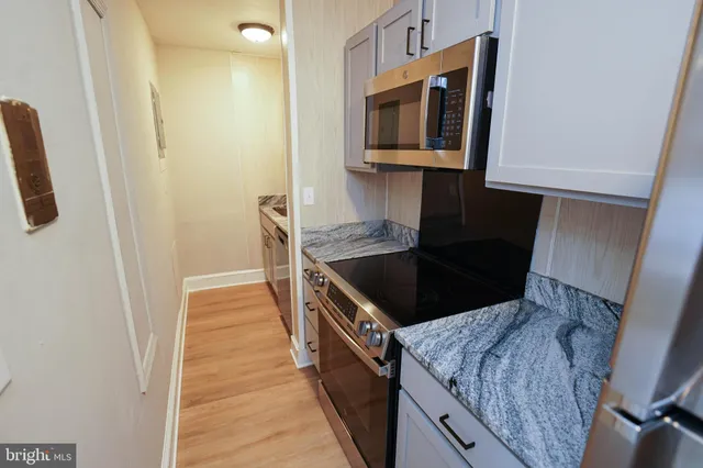 a kitchen with stainless steel appliances granite countertop a stove a sink and a microwave