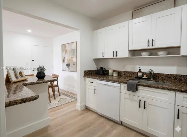 a kitchen with stainless steel appliances granite countertop a sink stove and white cabinets with wooden floor