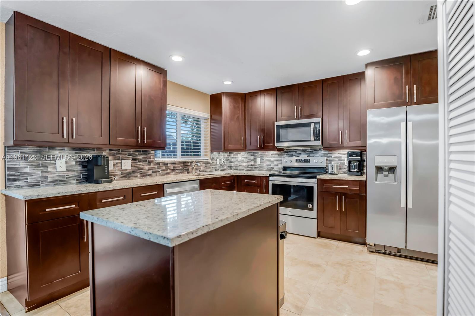 21451 Sawmill Court Boca Raton, FL 33498 - Photo 13 of 67 a kitchen with stainless steel appliances granite countertop a refrigerator stove microwave and sink