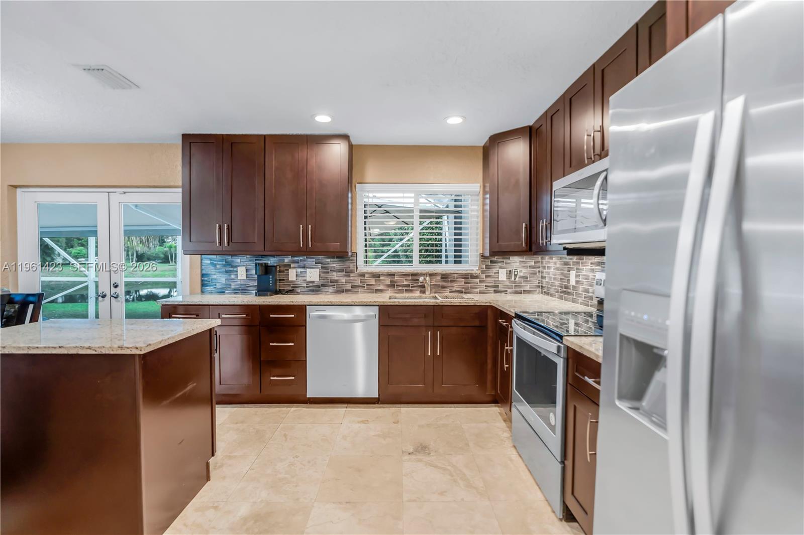21451 Sawmill Court Boca Raton, FL 33498 - Photo 15 of 67 a kitchen with stainless steel appliances granite countertop a sink stove and refrigerator