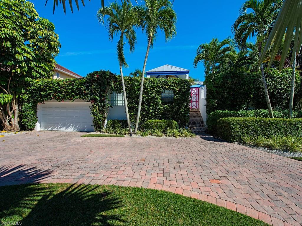 5138 Starfish Avenue Naples, FL 34103 - Photo 2 of 17 a view of a yard with plants and palm trees
