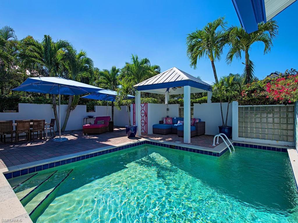 5138 Starfish Avenue Naples, FL 34103 - Photo 3 of 17 a view of a chair and table with umbrella in the garden