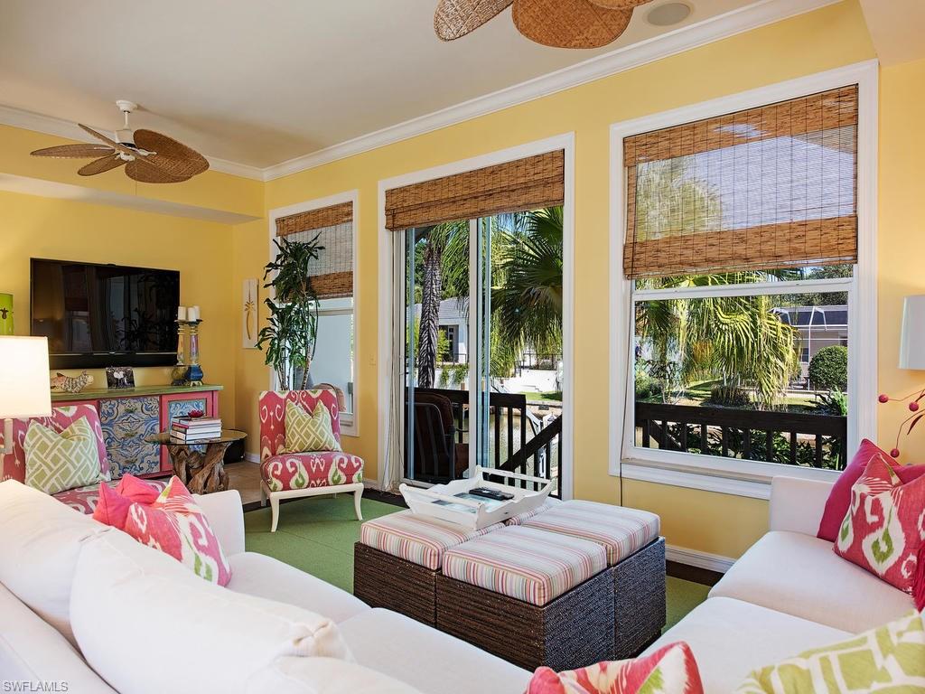 5138 Starfish Avenue Naples, FL 34103 - Photo 4 of 17 a living room with patio furniture and a flat screen tv