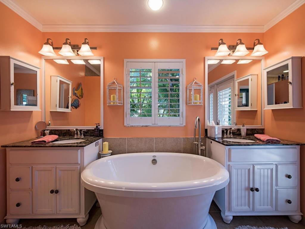 5138 Starfish Avenue Naples, FL 34103 - Photo 9 of 17 a white bath tub sitting in a bathroom next to a sink