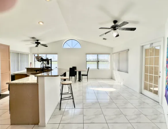 a living room with furniture a dining table and white walls
