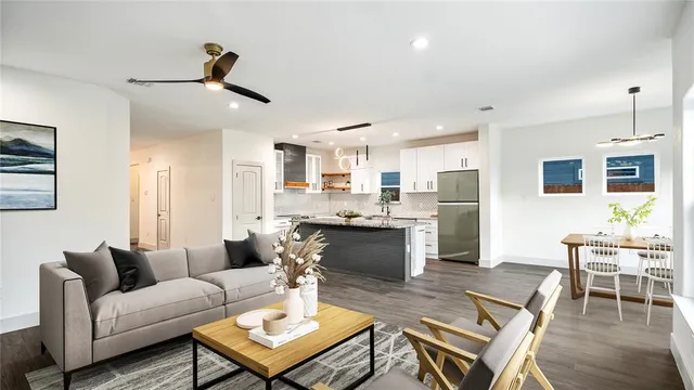 a living room with stainless steel appliances kitchen island granite countertop furniture and a view of kitchen