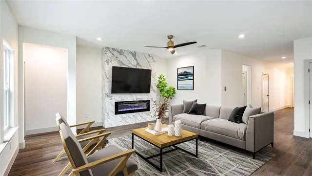 a living room with furniture a flat screen tv and a window