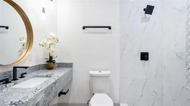 a bathroom with a granite countertop sink and a mirror