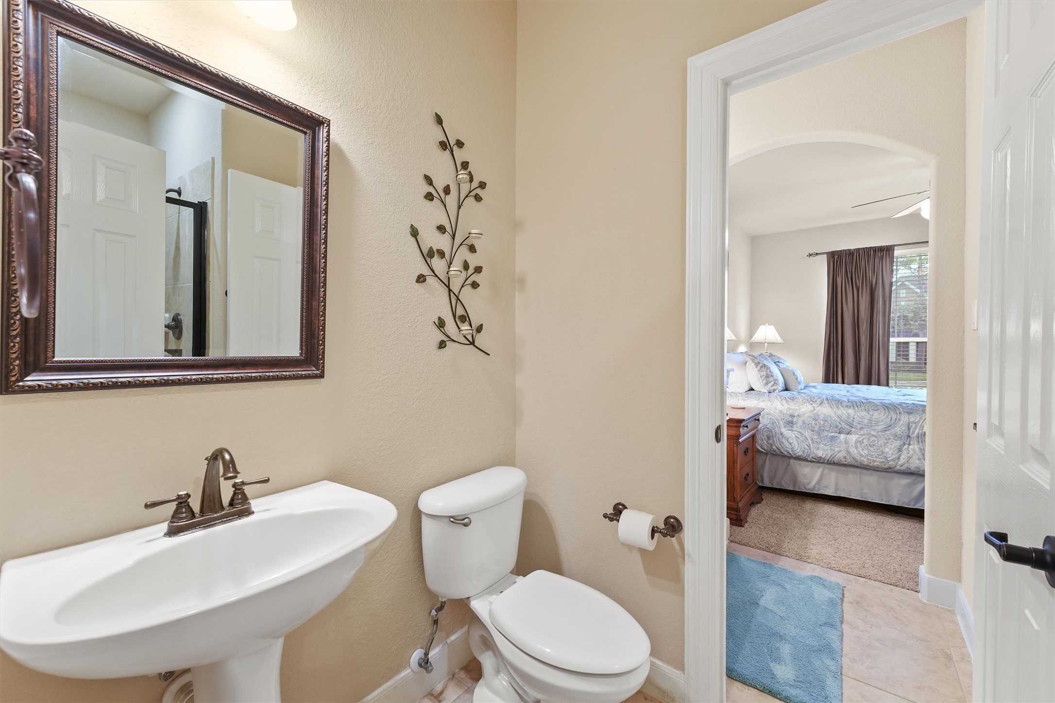 15702 Bellforest Court Houston, TX 77044 - Photo 14 of 38 a bathroom with a sink a toilet and a mirror