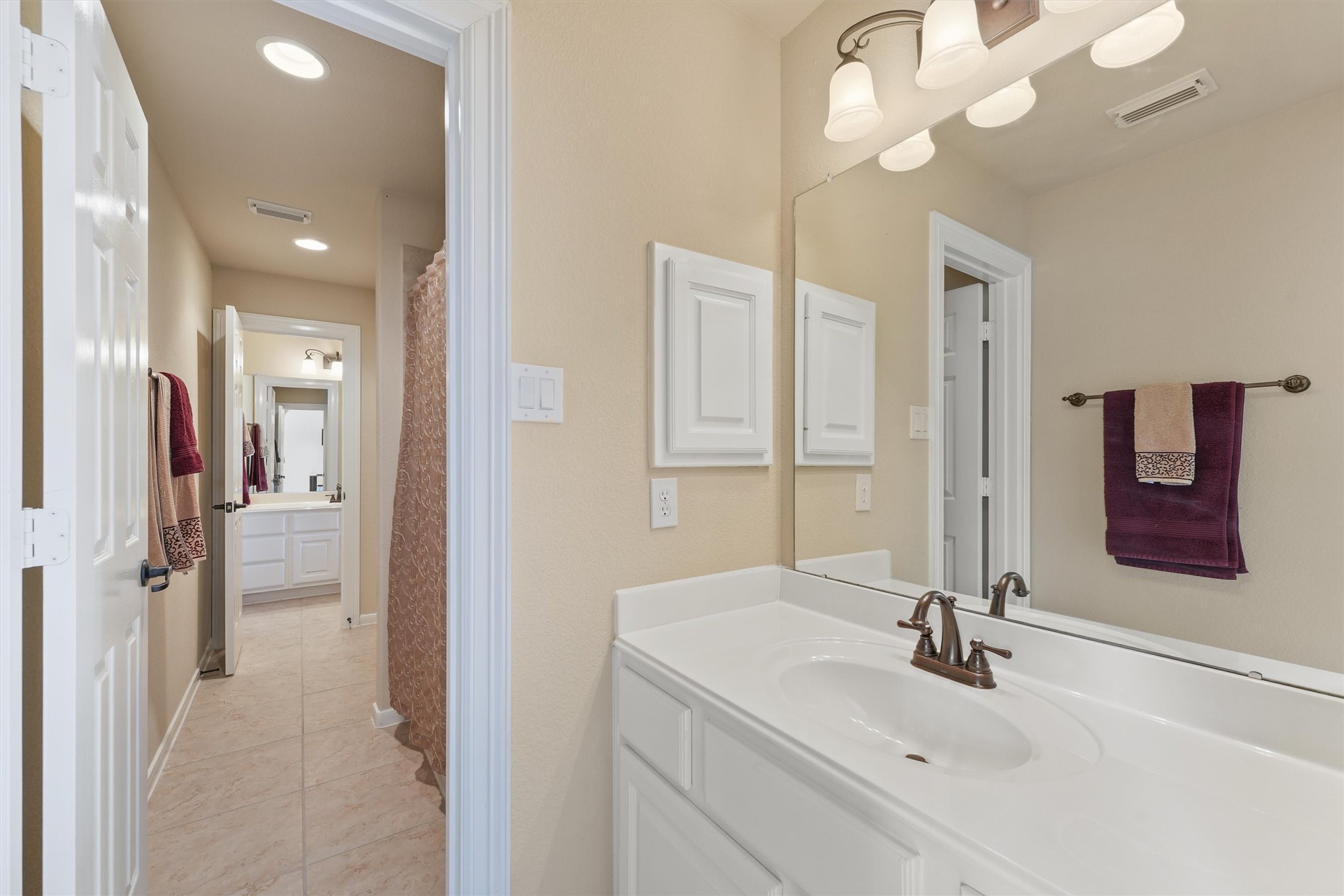 15702 Bellforest Court Houston, TX 77044 - Photo 25 of 38 a bathroom with a sink a mirror and a shower