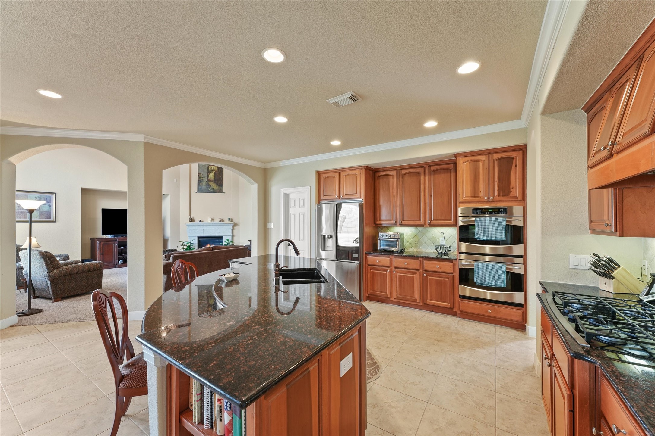 15702 Bellforest Court Houston, TX 77044 - Photo 9 of 38 a kitchen with stainless steel appliances granite countertop a stove top oven a sink a dining table and chairs