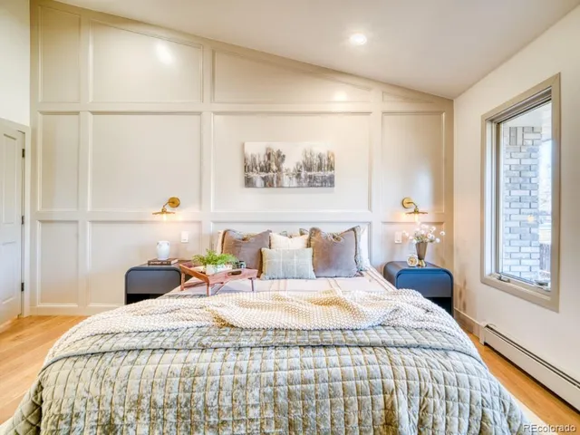 a bedroom with a bed and a painting on the wall