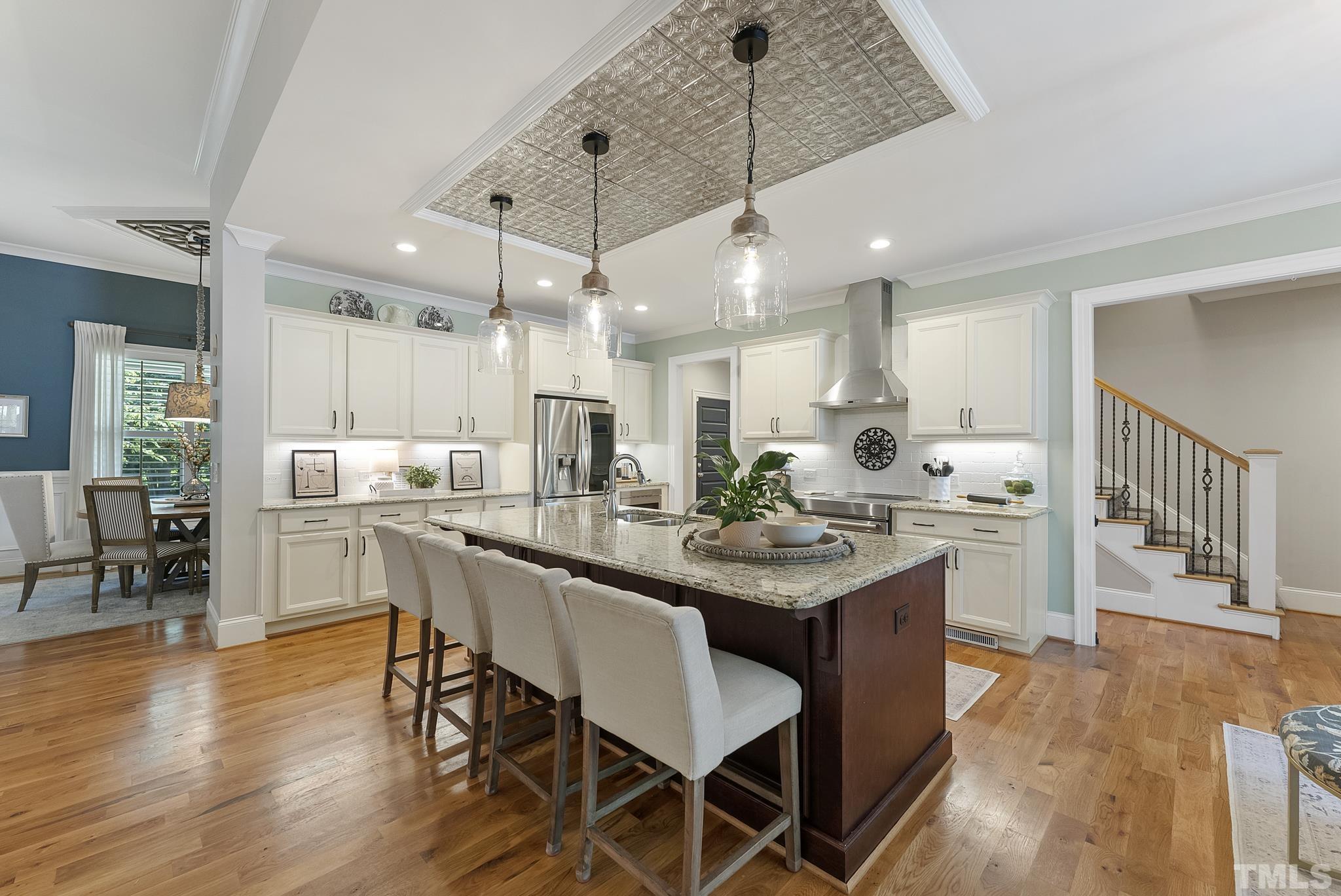 6121 Spring Branch Circle Raleigh, NC 27603 - Photo 11 of 60 a kitchen with stainless steel appliances kitchen island granite countertop a table chairs and a refrigerator