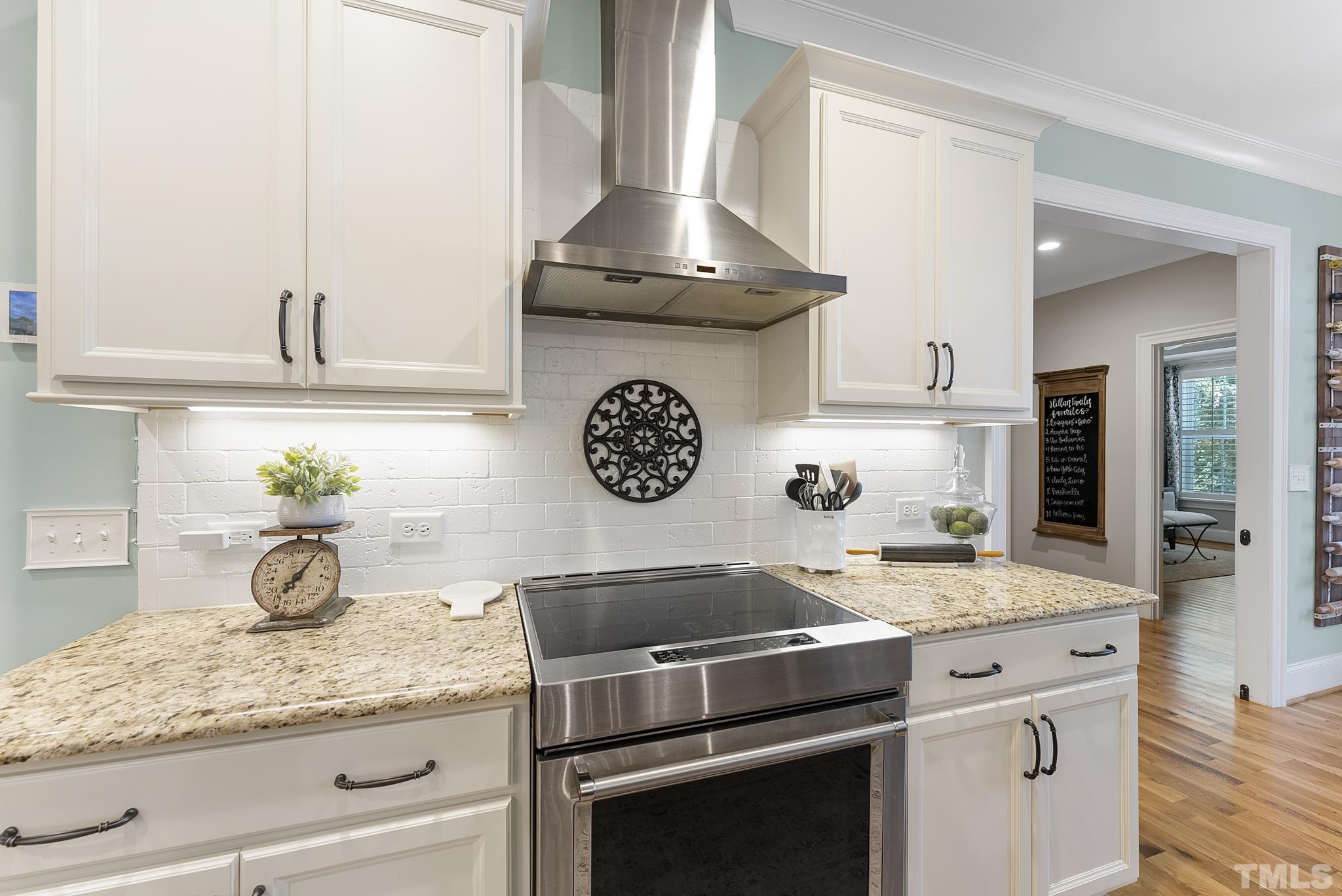 6121 Spring Branch Circle Raleigh, NC 27603 - Photo 15 of 60 a kitchen with granite countertop stainless steel appliances stove top oven and cabinets