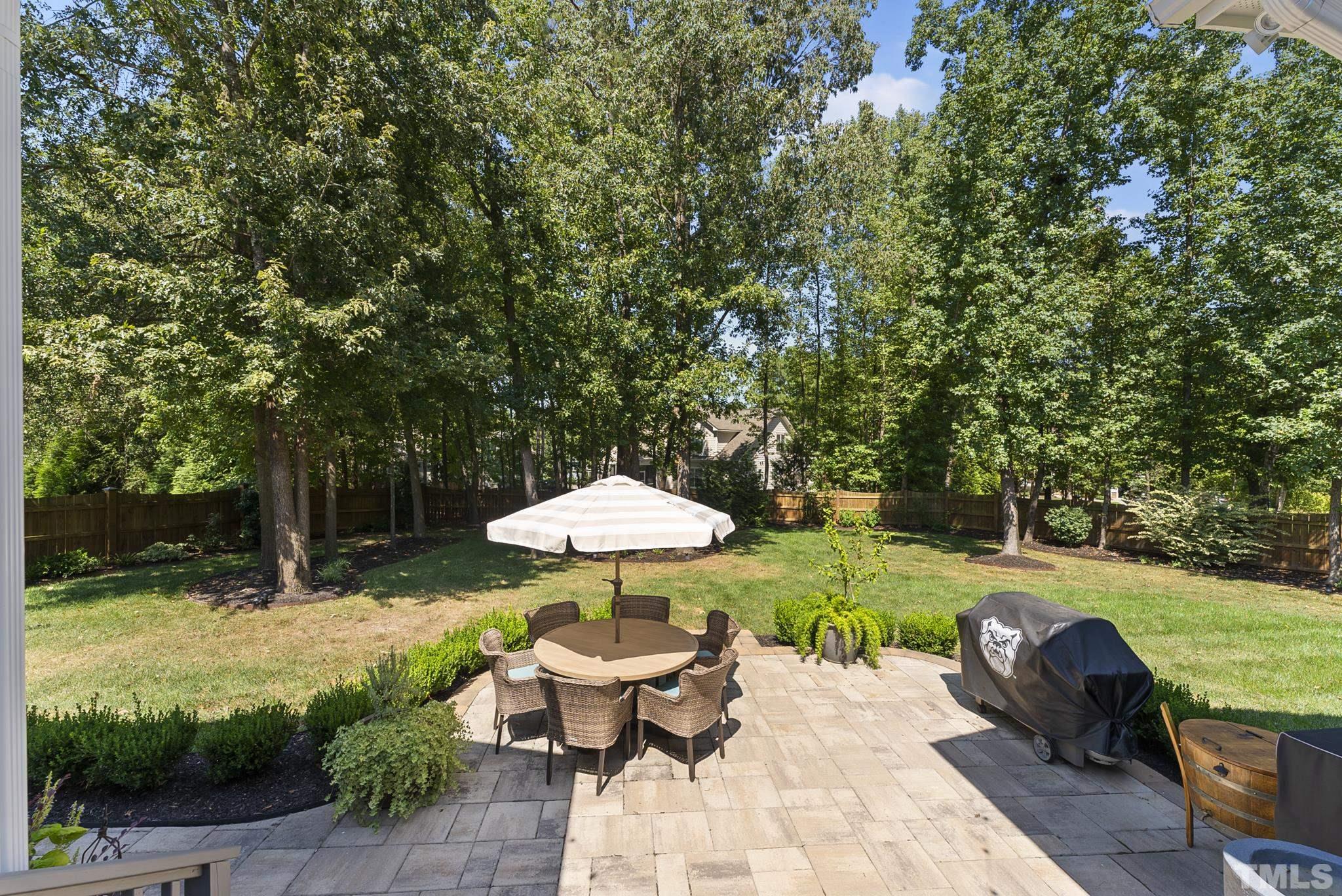 6121 Spring Branch Circle Raleigh, NC 27603 - Photo 43 of 60 a view of a backyard with table and chairs under an umbrella