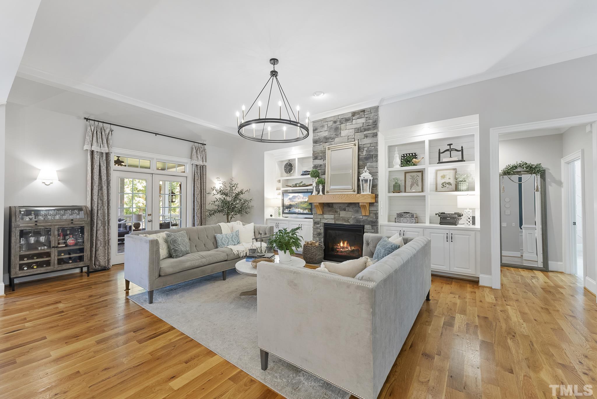 6121 Spring Branch Circle Raleigh, NC 27603 - Photo 7 of 60 a living room with furniture a fireplace and a chandelier