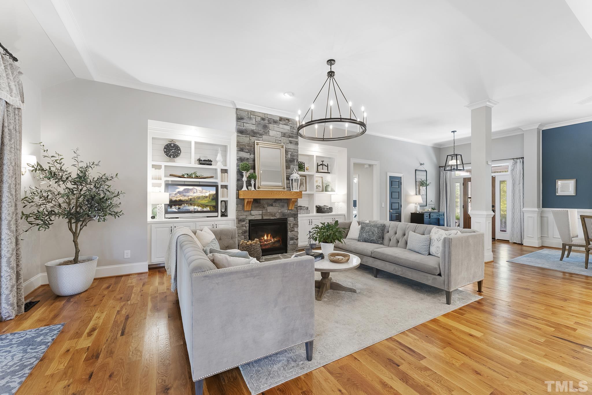 6121 Spring Branch Circle Raleigh, NC 27603 - Photo 9 of 60 a living room with furniture a fireplace and a chandelier