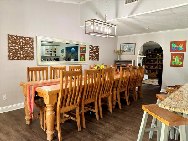 a dining room with furniture a chandelier and wooden floor