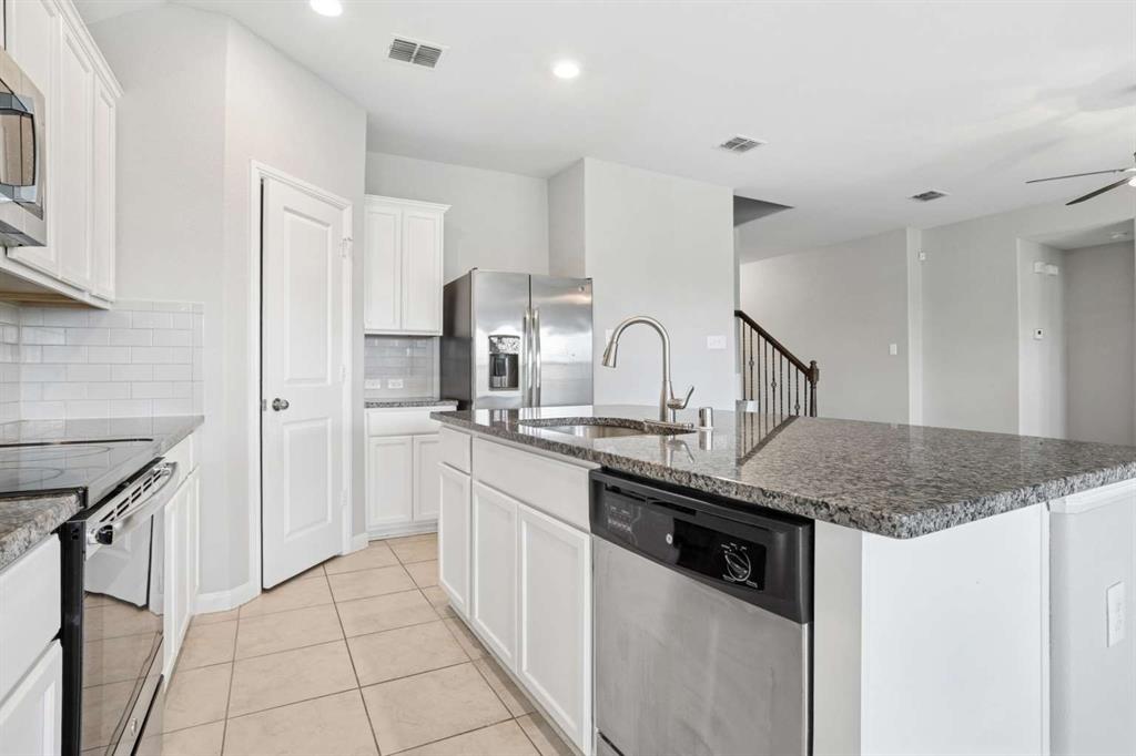 112 Garner Court Forney, TX 75126 - Photo 12 of 15 a kitchen with stainless steel appliances granite countertop a sink and dishwasher a refrigerator with wooden cabinets