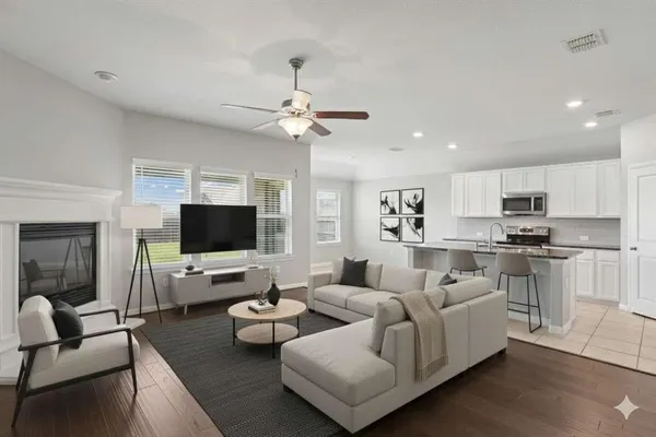 a living room with furniture kitchen view and a flat screen tv