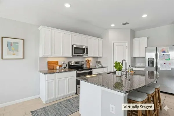 a kitchen with granite countertop a stove sink and cabinets