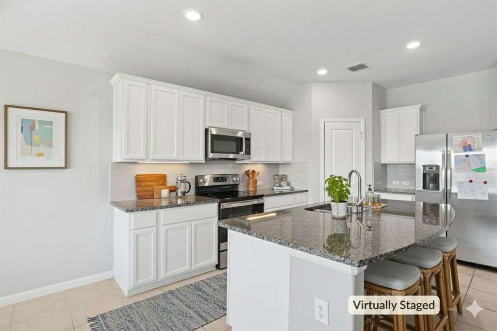 112 Garner Court Forney, TX 75126 - Photo 4 of 15 a kitchen with granite countertop a stove sink and cabinets