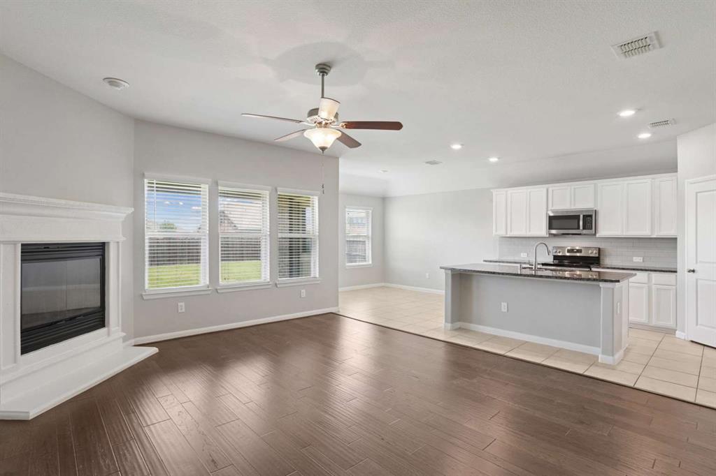 112 Garner Court Forney, TX 75126 - Photo 10 of 15 a view of an empty room with wooden floor and a kitchen