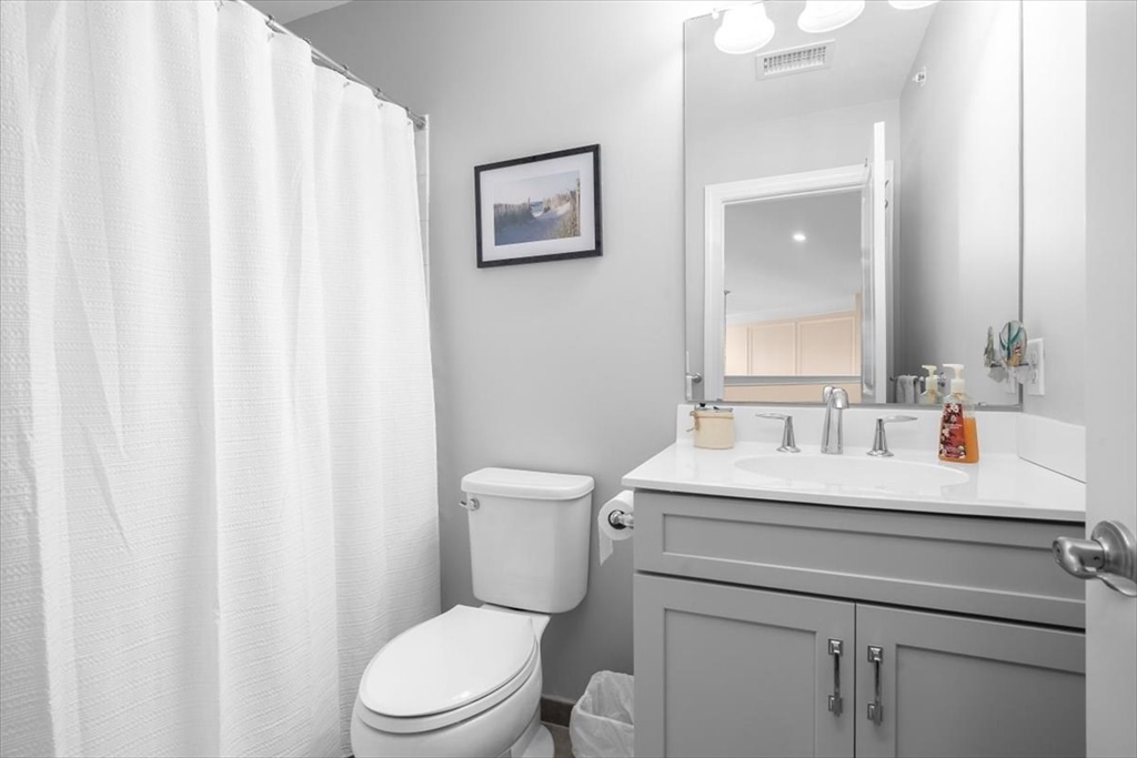 5 Brand Boulevard, Unit 5 Scituate, MA 02066 - Photo 23 of 42 a bathroom with a sink vanity mirror and toilet
